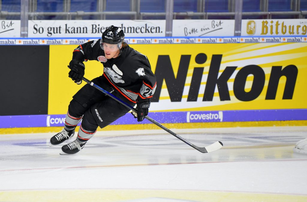 Eishockey-Spieler in Aaction vor Nikon-Banner