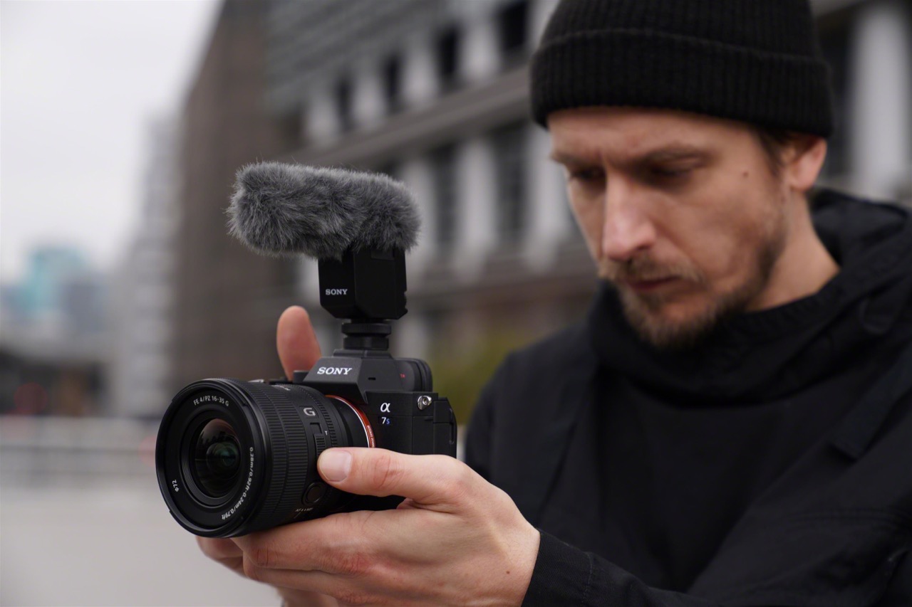 Abbildung Mann hält Kamera mit Weitwinkelobjektiv FE PZ 16-35 Millimeter F4 G von Sony in den Händen und filmt